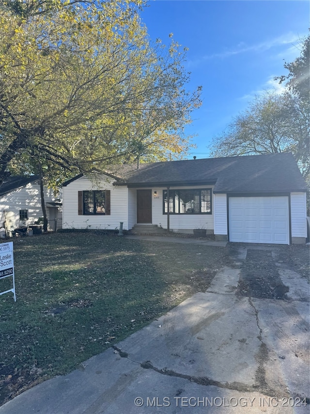 single story home with a front yard and a garage