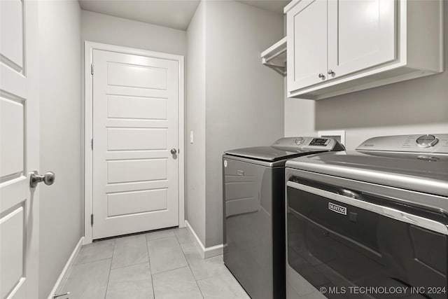 laundry area with cabinets, light tile patterned floors, and separate washer and dryer