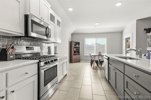 kitchen featuring white cabinets, appliances with stainless steel finishes, backsplash, and sink