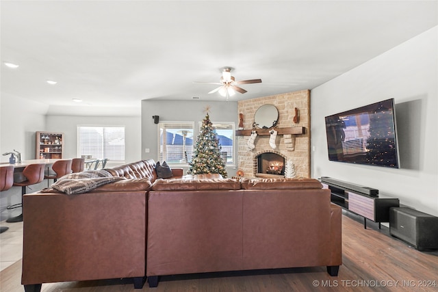 living room with ceiling fan, a fireplace, and wood-type flooring