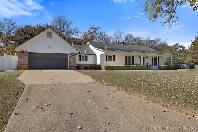 ranch-style home featuring a front yard, a porch, and a garage