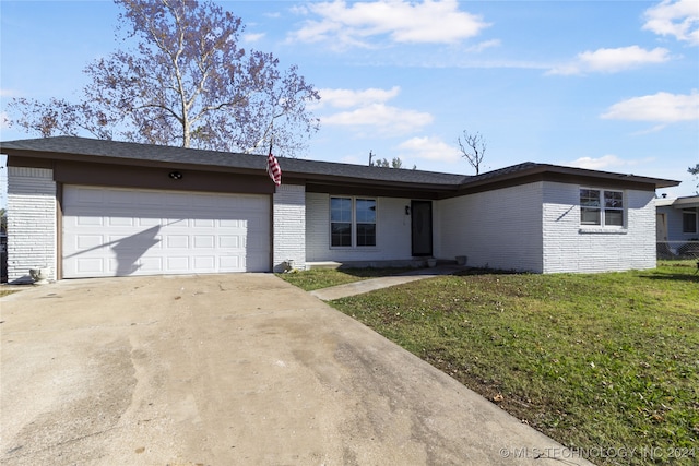 ranch-style home featuring a garage and a front lawn