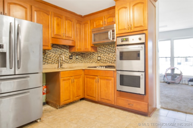 kitchen with appliances with stainless steel finishes, backsplash, and sink