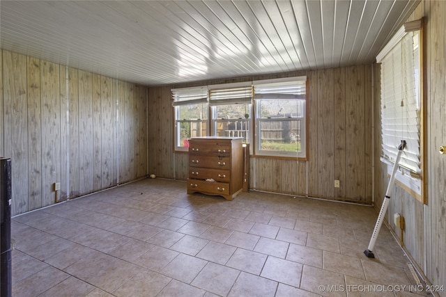 tiled spare room with wood walls and wooden ceiling