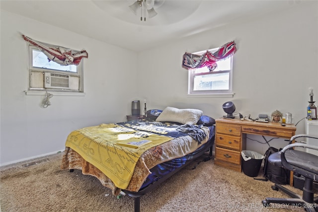 carpeted bedroom featuring multiple windows and ceiling fan