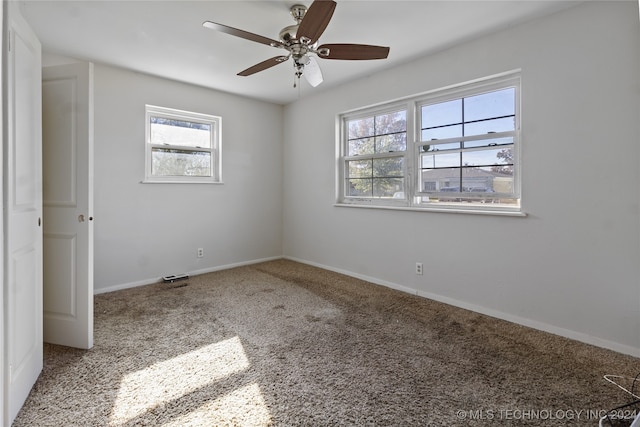 carpeted spare room with plenty of natural light and ceiling fan