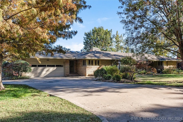 single story home with a garage and a front yard