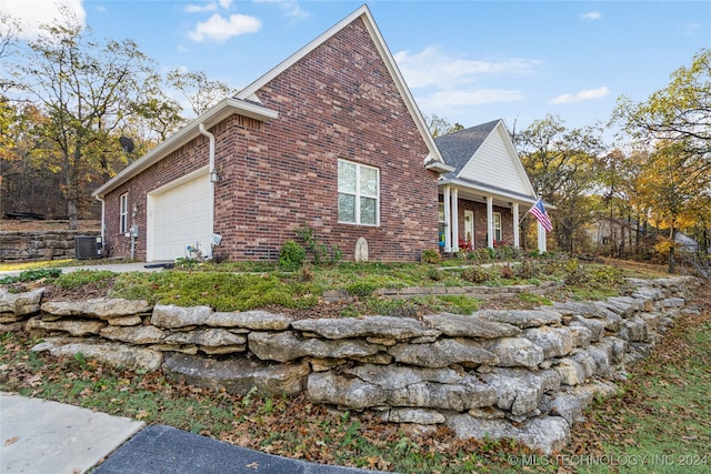 view of home's exterior with a garage and cooling unit