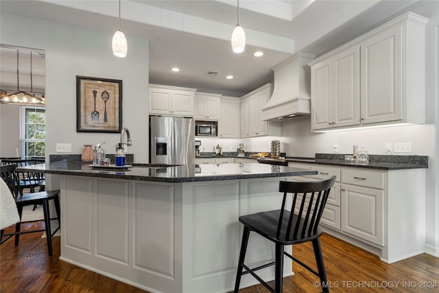 kitchen with appliances with stainless steel finishes, dark hardwood / wood-style flooring, premium range hood, and white cabinetry