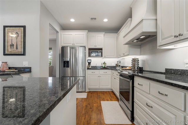 kitchen with premium range hood, white cabinetry, stainless steel appliances, and dark hardwood / wood-style floors