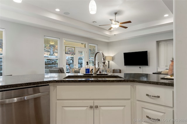 kitchen featuring dishwasher, a raised ceiling, white cabinetry, and sink