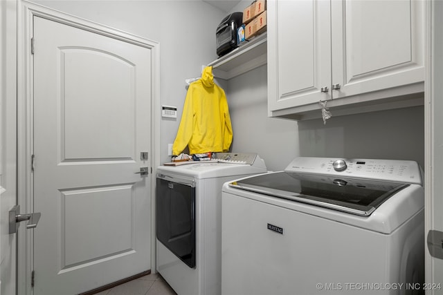 laundry room featuring cabinets, independent washer and dryer, and light tile patterned floors