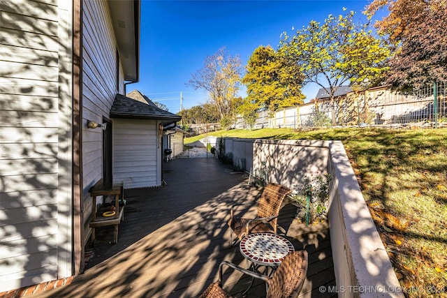 wooden terrace featuring a yard