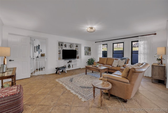 living room featuring light tile patterned flooring and built in shelves