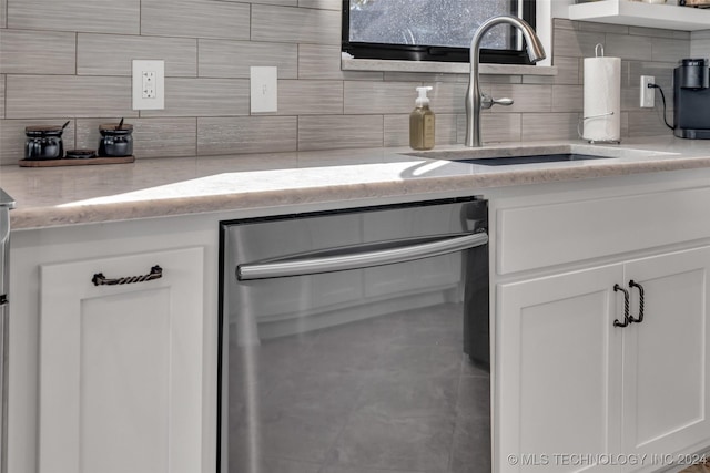 kitchen with sink, white cabinetry, light stone counters, and decorative backsplash