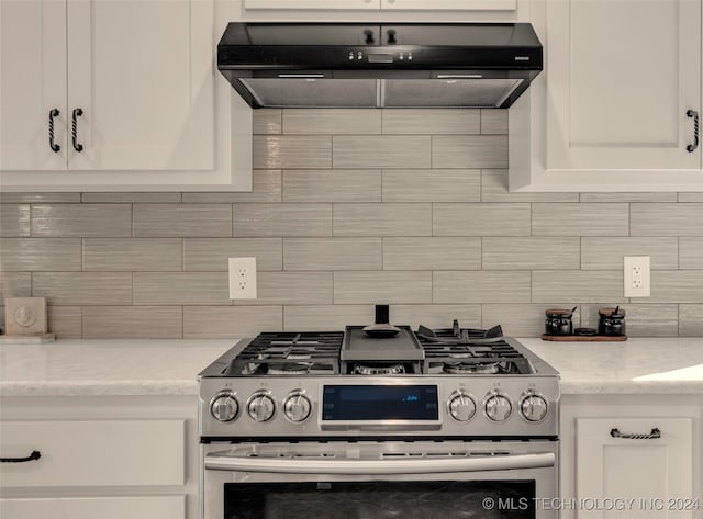 kitchen with white cabinets, stainless steel gas stove, and decorative backsplash