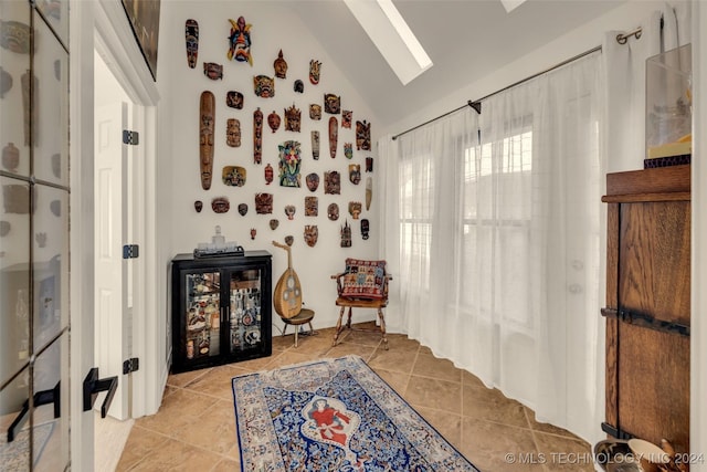 living area featuring lofted ceiling and light tile patterned floors