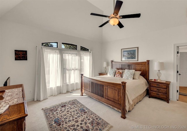 bedroom with ceiling fan, light colored carpet, and lofted ceiling