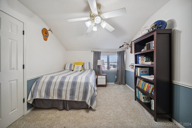 carpeted bedroom with ceiling fan and vaulted ceiling