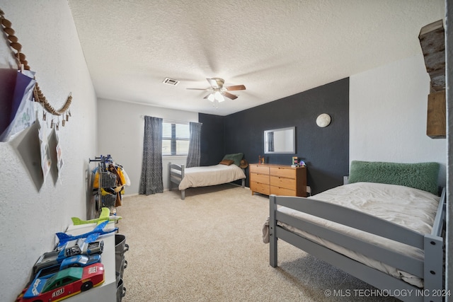 bedroom featuring ceiling fan, a textured ceiling, and carpet floors