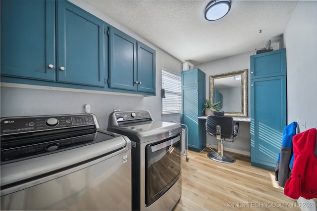 washroom featuring a textured ceiling, light hardwood / wood-style floors, cabinets, and independent washer and dryer