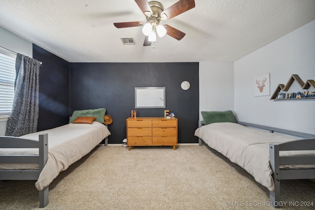 bedroom featuring ceiling fan, a textured ceiling, and carpet flooring