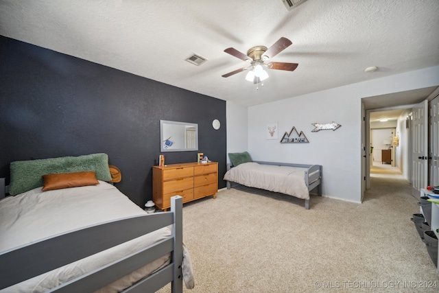 carpeted bedroom with a textured ceiling and ceiling fan