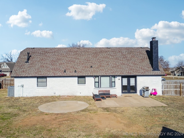 rear view of house featuring french doors, a patio, cooling unit, and a lawn