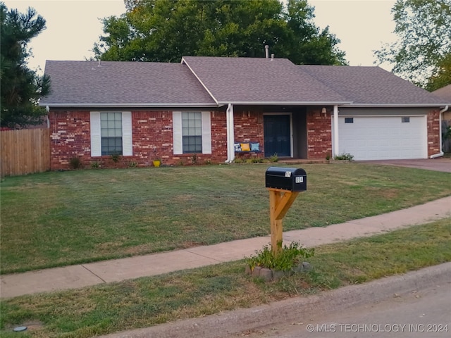 ranch-style home with a garage and a front lawn