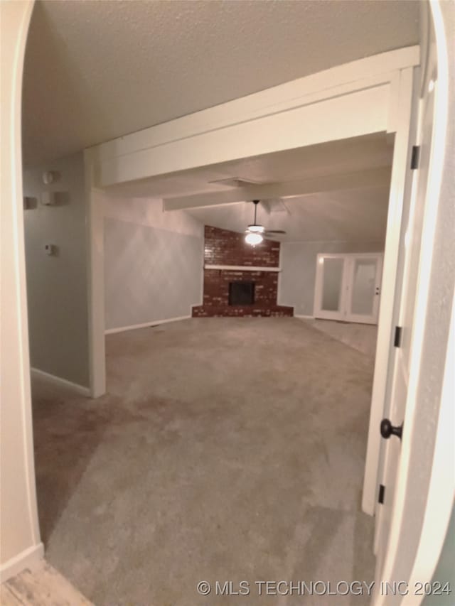 hall featuring carpet and a textured ceiling