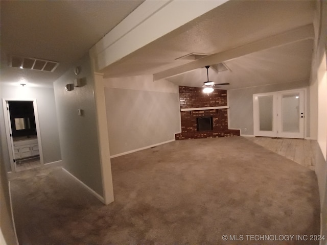 unfurnished living room with beam ceiling, a fireplace, and carpet floors