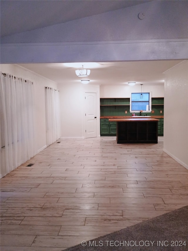 interior space featuring light hardwood / wood-style flooring, green cabinetry, and lofted ceiling