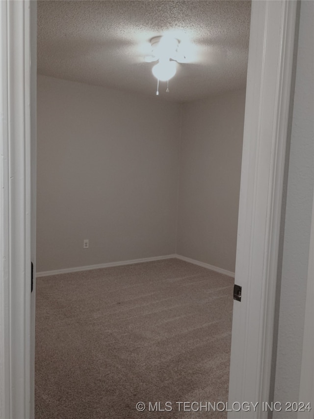 spare room featuring carpet and a textured ceiling