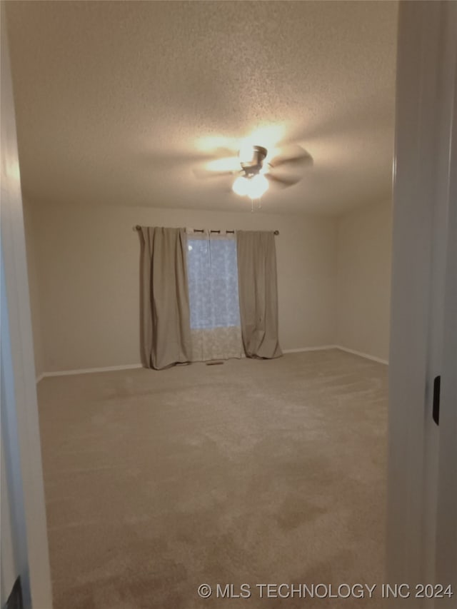 carpeted empty room featuring a textured ceiling