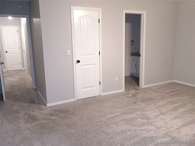 unfurnished bedroom featuring carpet floors and ensuite bathroom