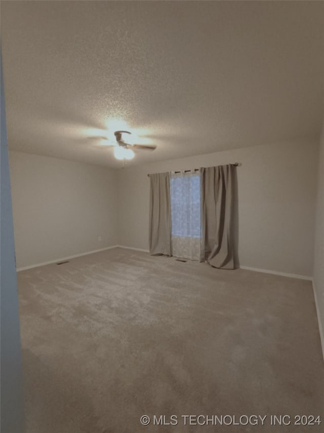 spare room with carpet flooring and a textured ceiling