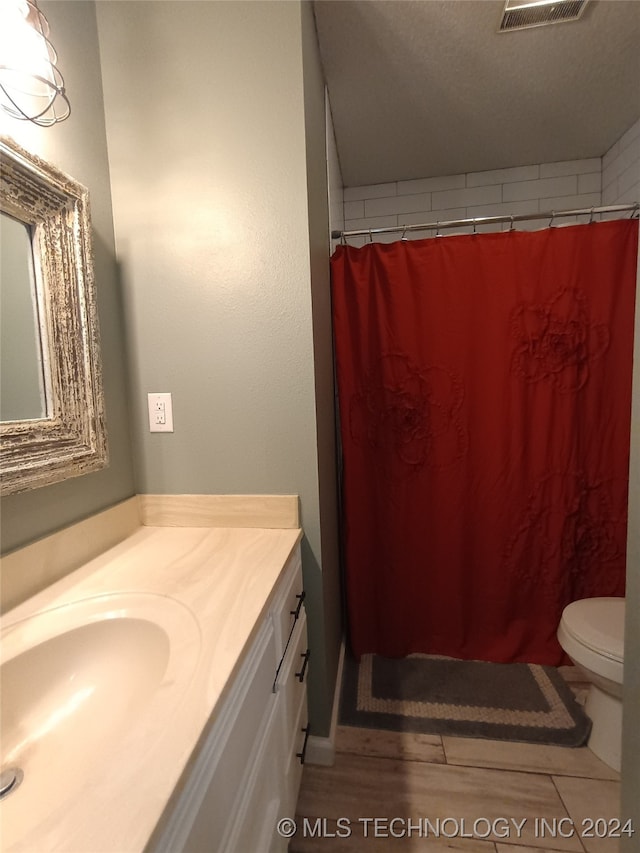 bathroom featuring vanity, wood-type flooring, a textured ceiling, and walk in shower