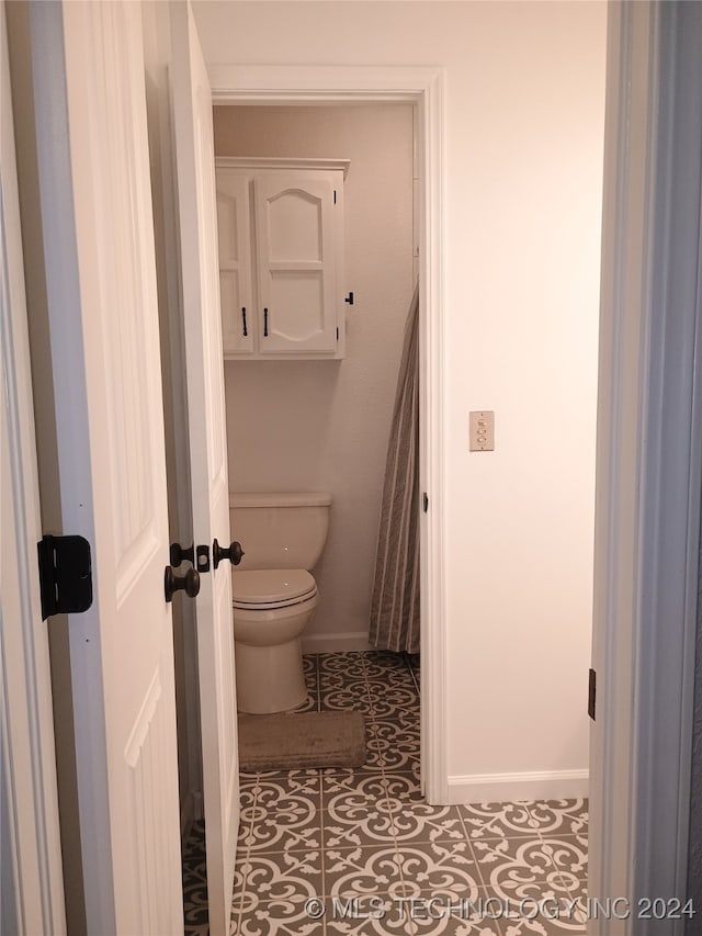 bathroom featuring toilet and tile patterned floors