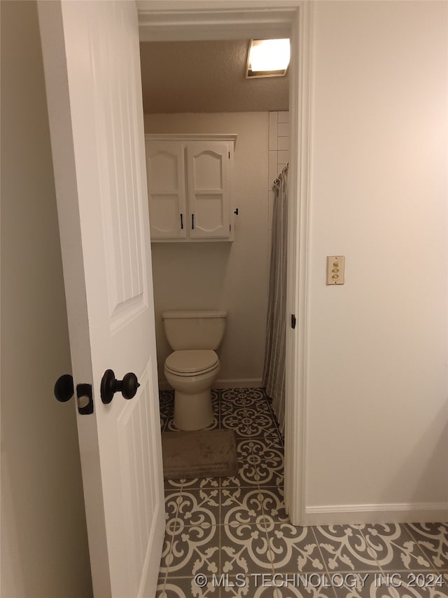 bathroom with tile patterned flooring and toilet