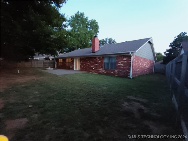 rear view of house with a patio and a lawn