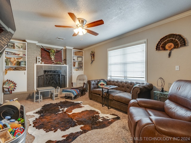 living room featuring carpet, crown molding, ceiling fan, a fireplace, and a textured ceiling