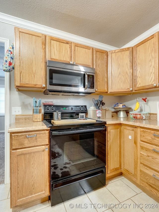 kitchen featuring light tile patterned floors, a textured ceiling, black range with electric stovetop, and ornamental molding