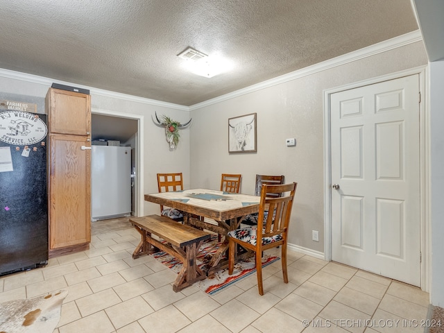 dining area with light tile patterned flooring, a textured ceiling, and ornamental molding