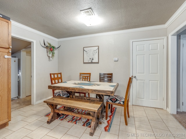 dining area with light tile patterned floors, a textured ceiling, and ornamental molding