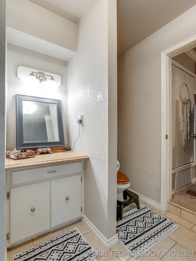 bathroom featuring tile patterned floors, vanity, and toilet