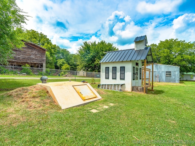 entry to storm shelter featuring a yard and an outdoor structure