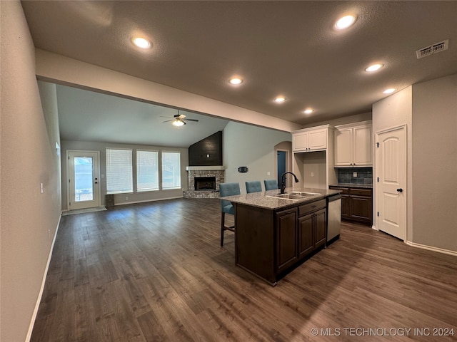 kitchen featuring a kitchen island with sink, white cabinets, sink, vaulted ceiling, and ceiling fan