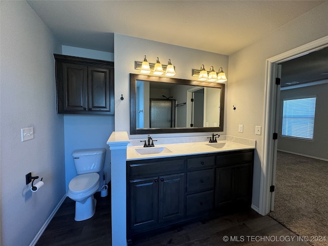 bathroom featuring walk in shower, hardwood / wood-style floors, vanity, and toilet