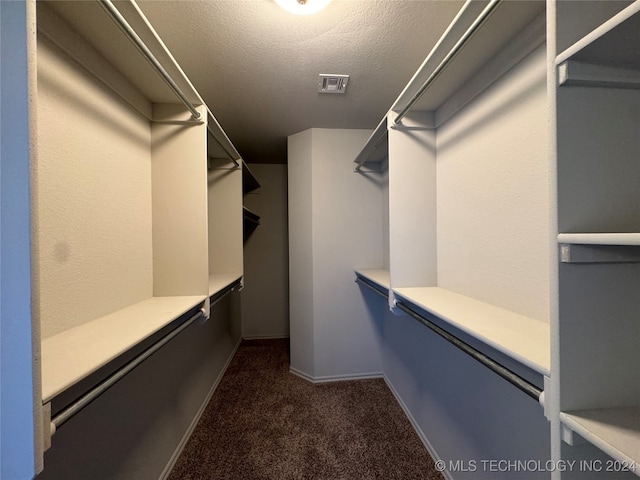 spacious closet featuring dark colored carpet