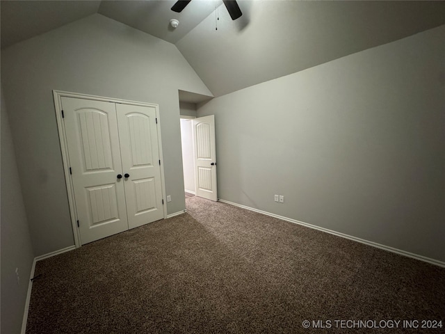 unfurnished bedroom featuring ceiling fan, a closet, dark carpet, and vaulted ceiling